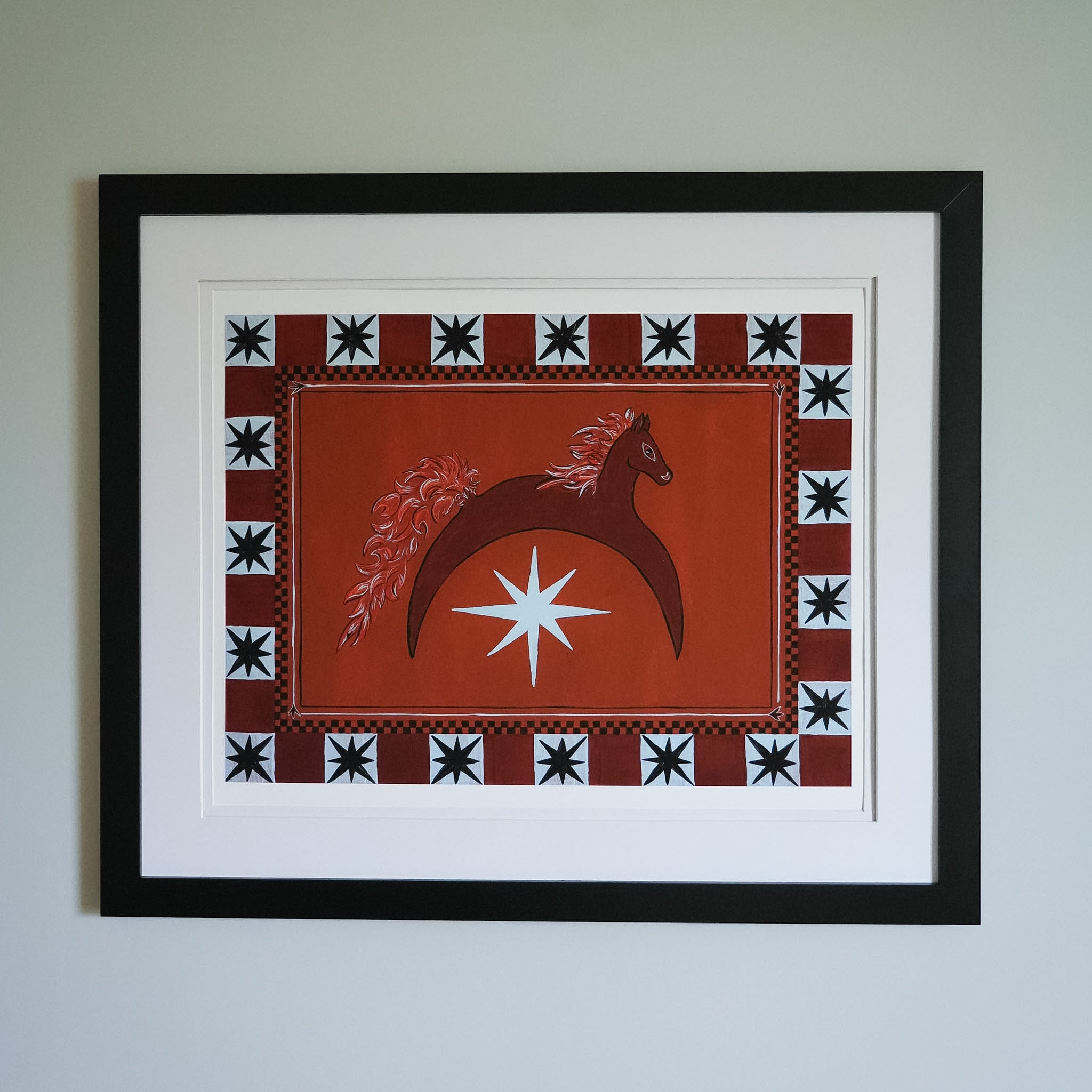 Framed artwork with a horse and star design on an orange background