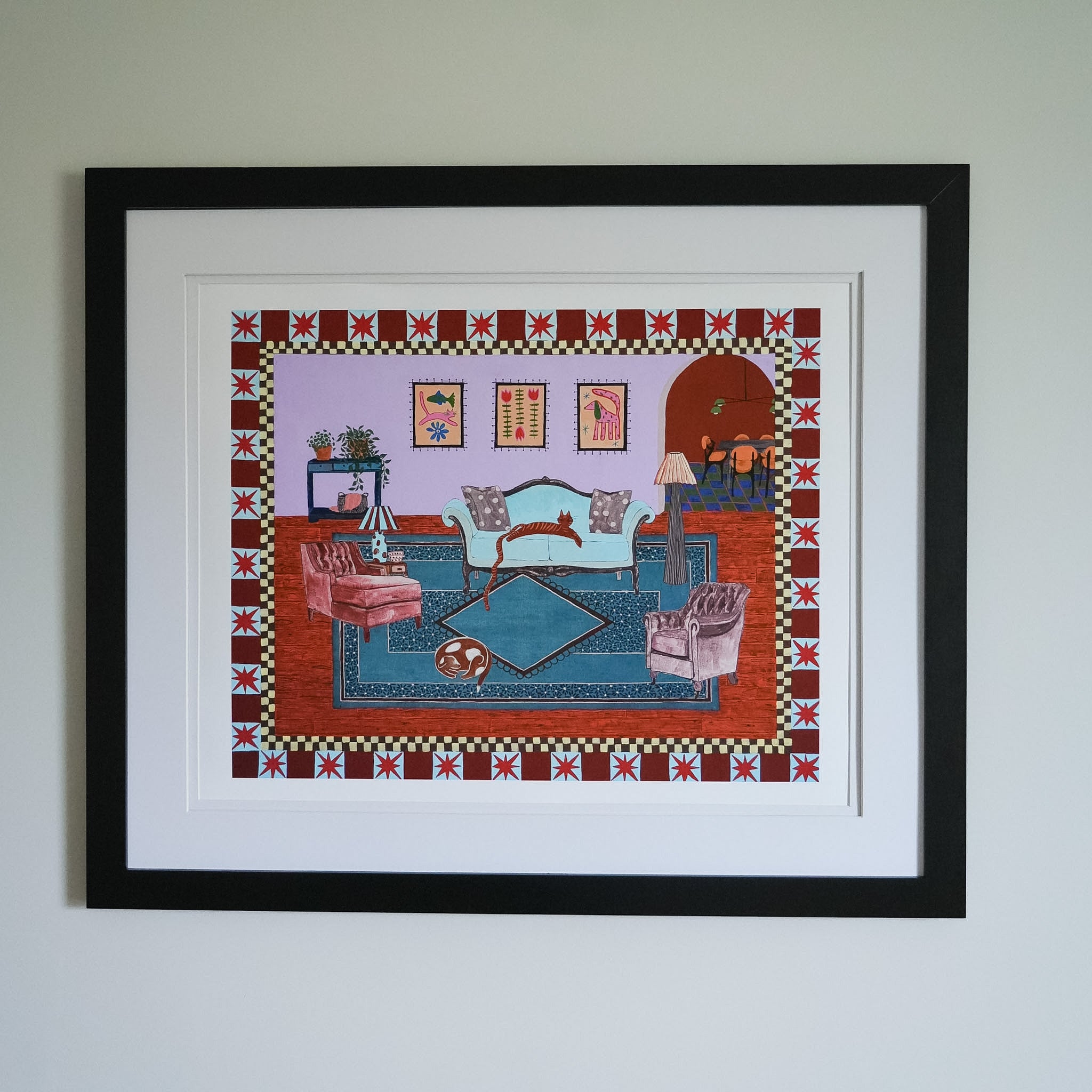Framed artwork of a living room scene with decorative border